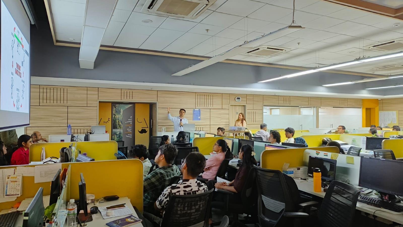 Sahej giving a talk to a room full of people at an office